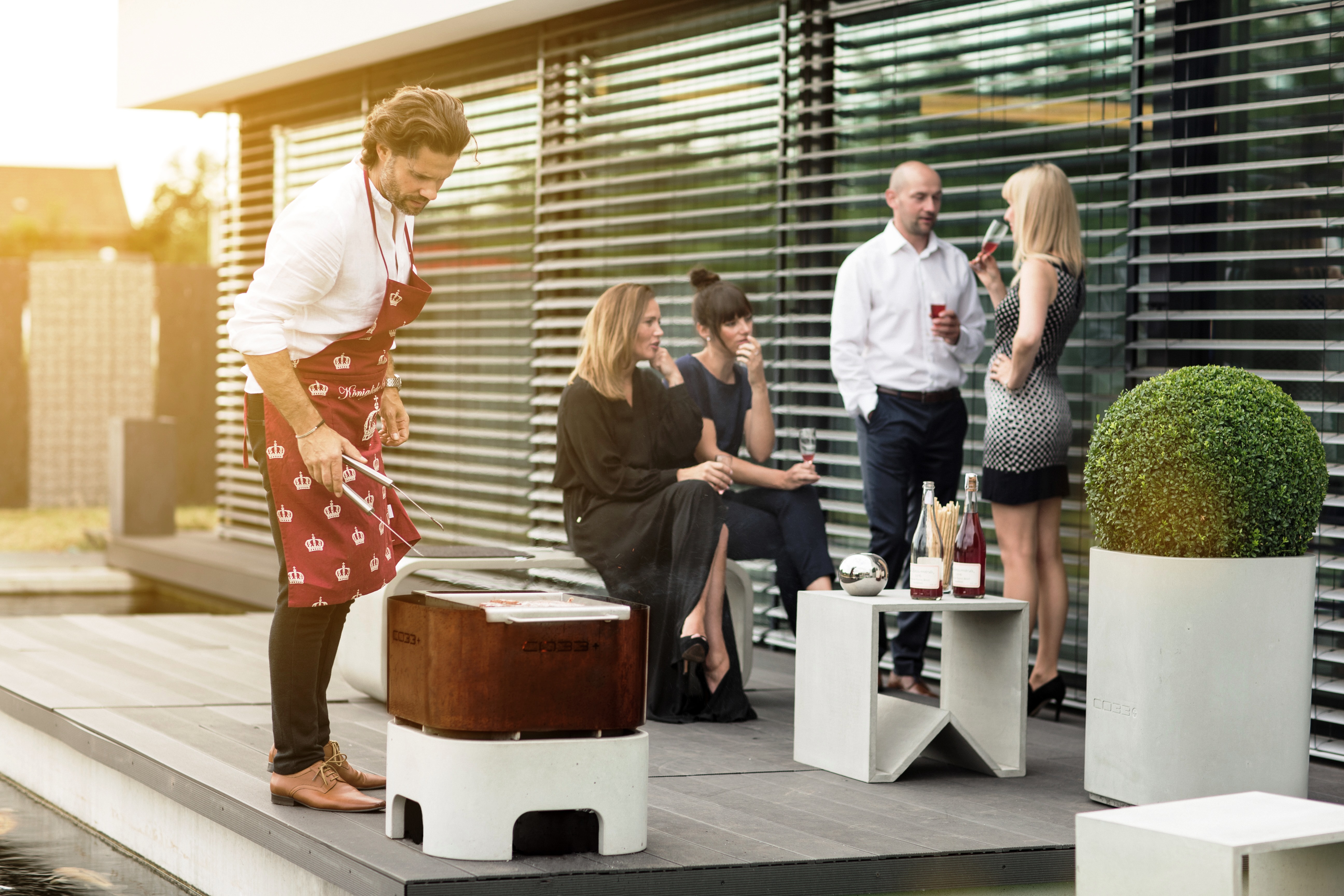 Grillparty-mit-Freunden-am-Feuerkorb-aus-Beton-und-Edelstahl