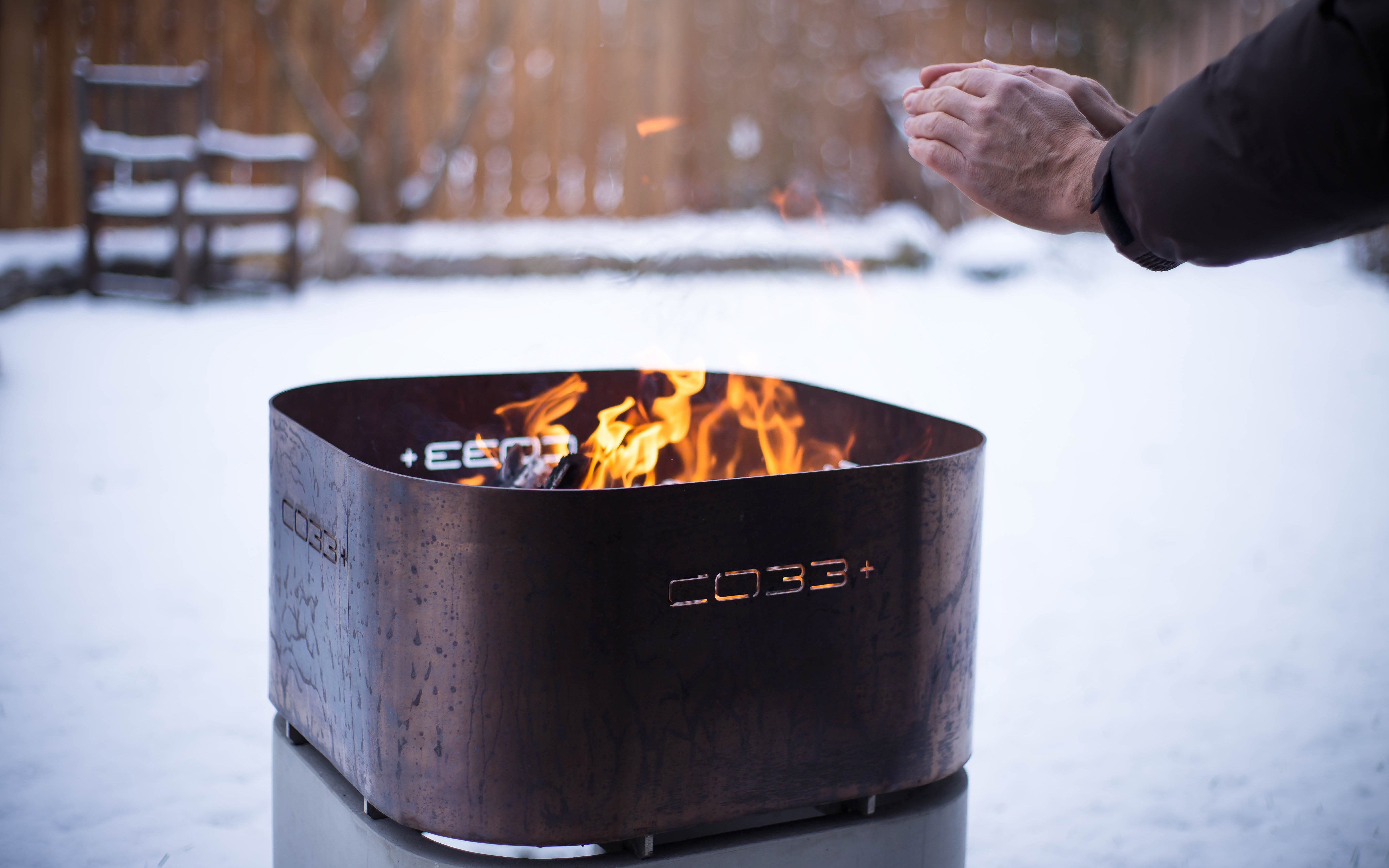 F3-opus-ignis CO33 Betonmöbel Feuerkorb aus Beton und Edelstahl in Verwendung am wärmenden Feuer im Winter