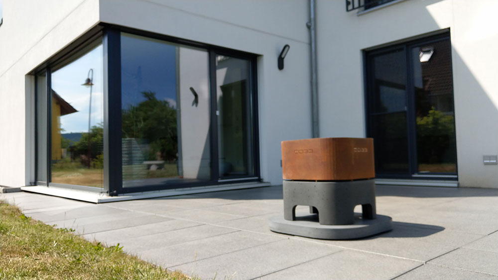 Dark grey concrete and Corten steel fire bowl with foundation plate
